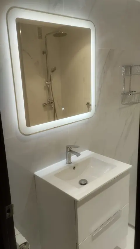 Mueble de lavabo blanco con espejo LED y revestimiento de efecto mármol